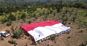 Polri dan Eks Napiter Bentangkan Bendera Merah Putih Raksasa di Gunung Biru Poso