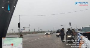 Bhabinkamtibmas Desa Setiamulya Bantu Warga Terjebak Banjir di depan Gerbang Tol Tarumajaya